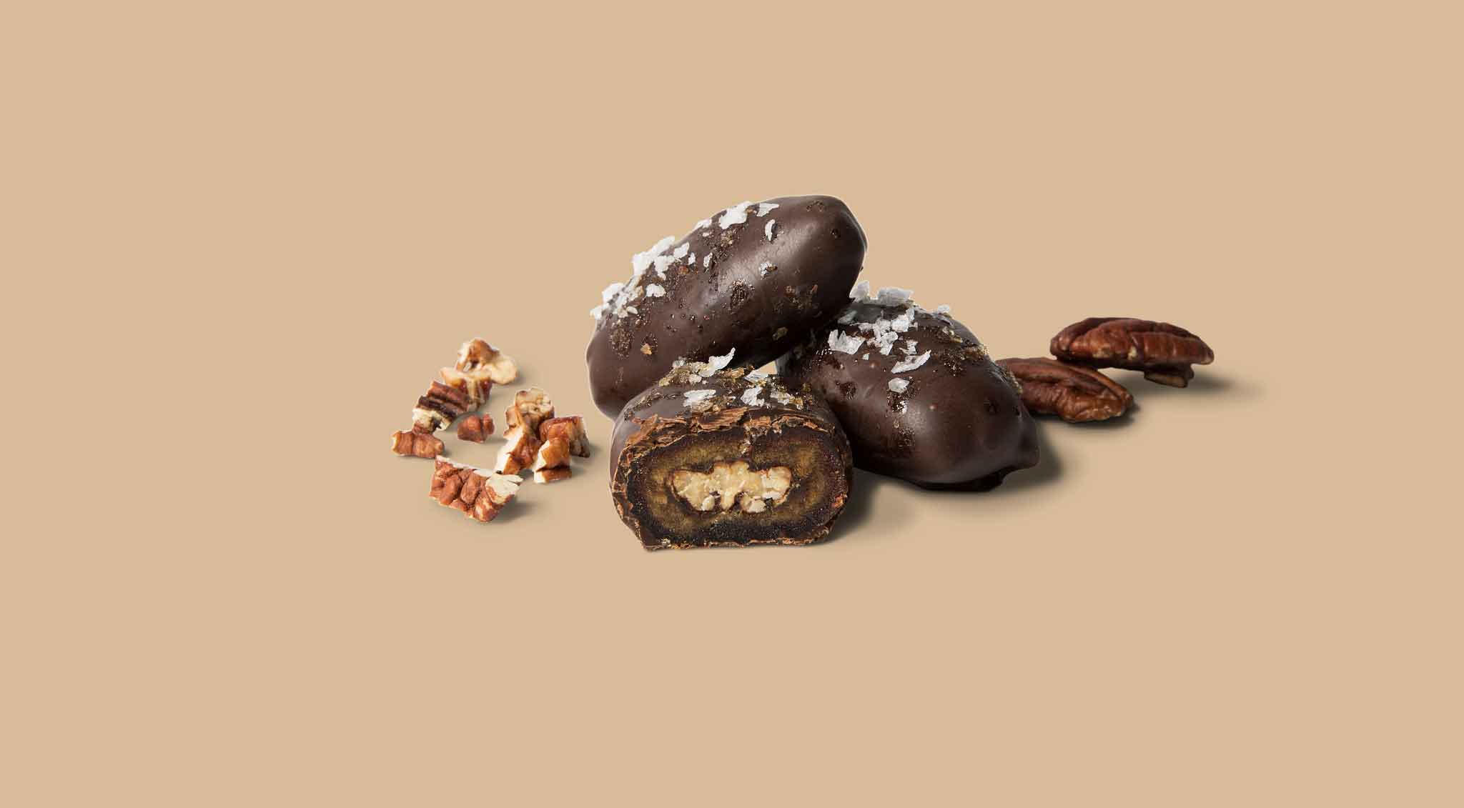 Chocolate-covered treats with nuts on a beige background